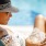 woman reading book poolside
